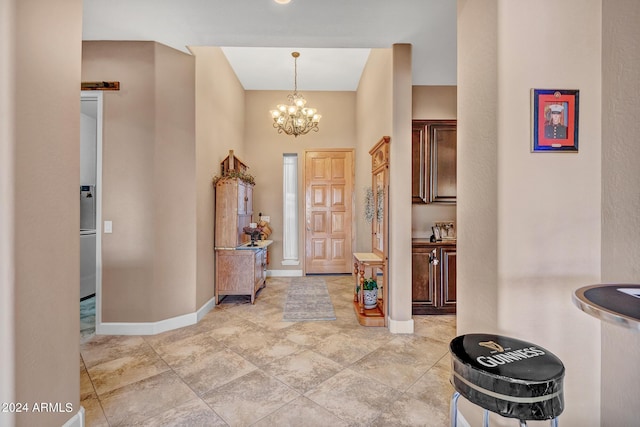 entryway with baseboards and a chandelier