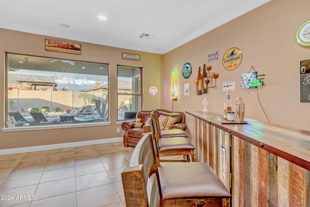 living area with plenty of natural light, visible vents, ornamental molding, and light tile patterned flooring