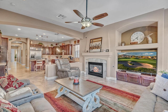 living area featuring a fireplace, recessed lighting, visible vents, ceiling fan, and arched walkways