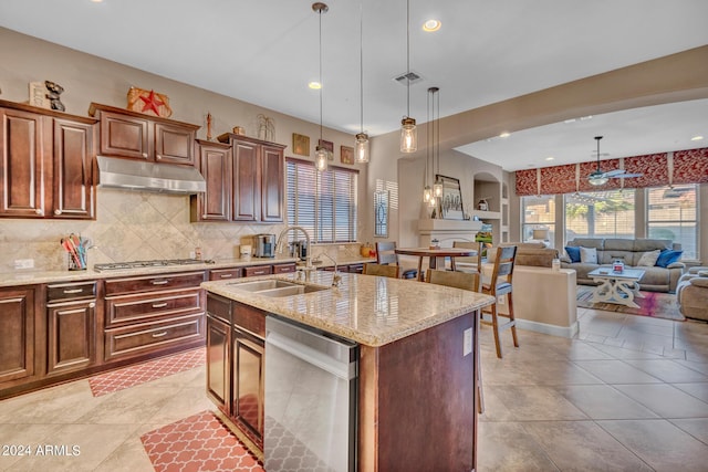 kitchen with backsplash, under cabinet range hood, visible vents, appliances with stainless steel finishes, and a sink