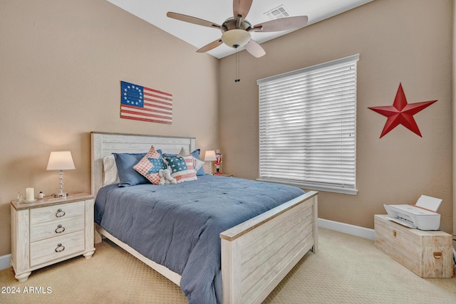 bedroom featuring visible vents, baseboards, multiple windows, and light colored carpet