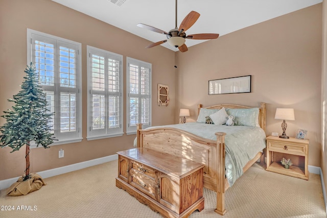 carpeted bedroom featuring visible vents, baseboards, multiple windows, and ceiling fan