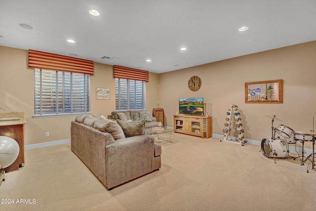 living area featuring visible vents, baseboards, recessed lighting, and light colored carpet