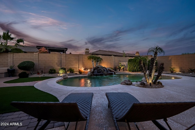 pool at dusk with a patio, a fenced backyard, and a fenced in pool