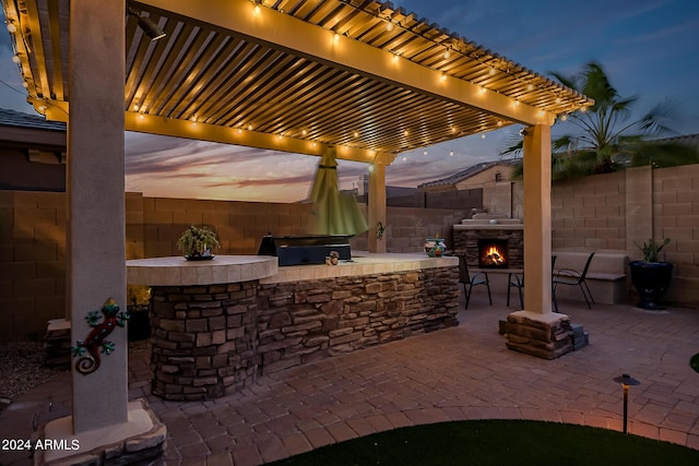 view of patio with a grill, a pergola, a fenced backyard, outdoor dry bar, and an outdoor kitchen