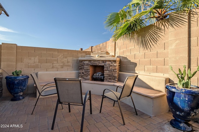 view of patio / terrace with a fenced backyard and an outdoor stone fireplace