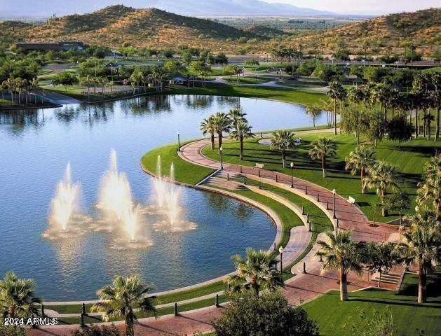 surrounding community with a water and mountain view and a lawn