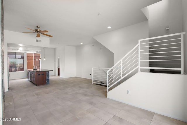 unfurnished living room featuring sink and ceiling fan