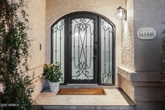 doorway to property featuring a gate and stucco siding
