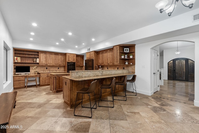 kitchen featuring recessed lighting, open shelves, tasteful backsplash, a peninsula, and arched walkways