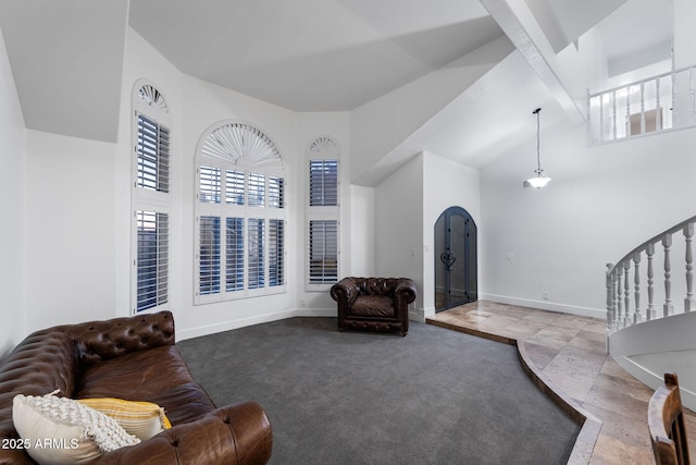 living room featuring baseboards, stairway, arched walkways, and a healthy amount of sunlight