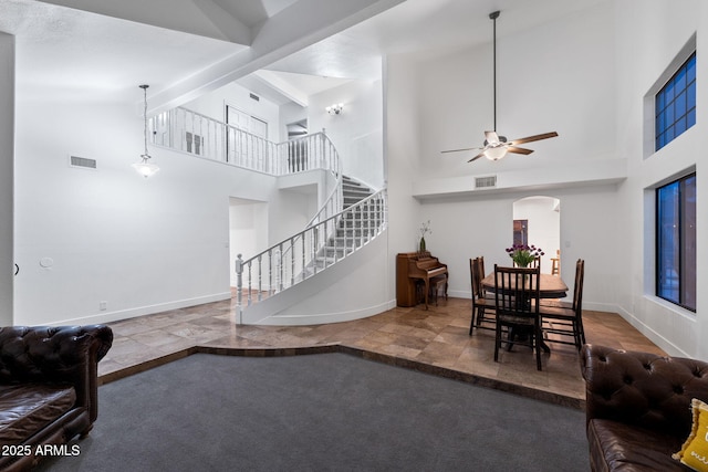 living room with high vaulted ceiling, ceiling fan, stairs, visible vents, and arched walkways