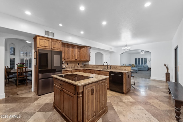 kitchen featuring black appliances, arched walkways, visible vents, and a peninsula