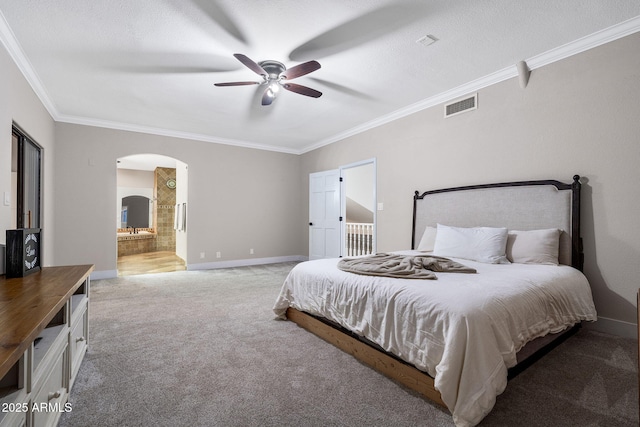 carpeted bedroom with baseboards, visible vents, arched walkways, and crown molding
