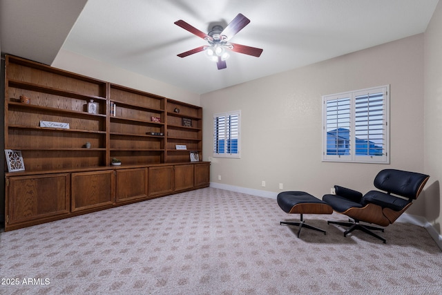 living area with baseboards, a ceiling fan, and carpet floors