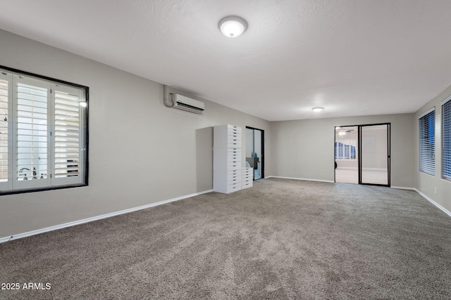interior space featuring baseboards, carpet floors, and an AC wall unit