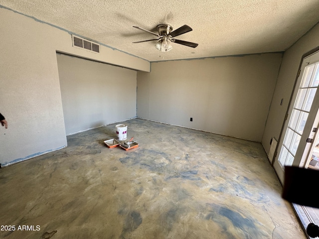 interior space with ceiling fan, concrete floors, and a textured ceiling