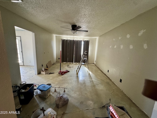 unfurnished room with ceiling fan and a textured ceiling