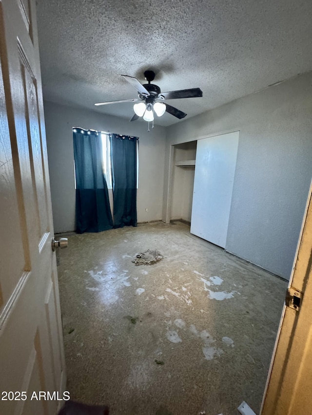 unfurnished bedroom with ceiling fan, a closet, and a textured ceiling