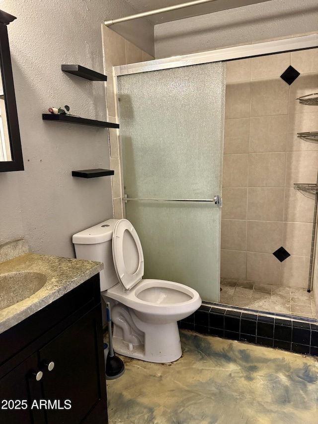 bathroom with vanity, toilet, an enclosed shower, and concrete floors