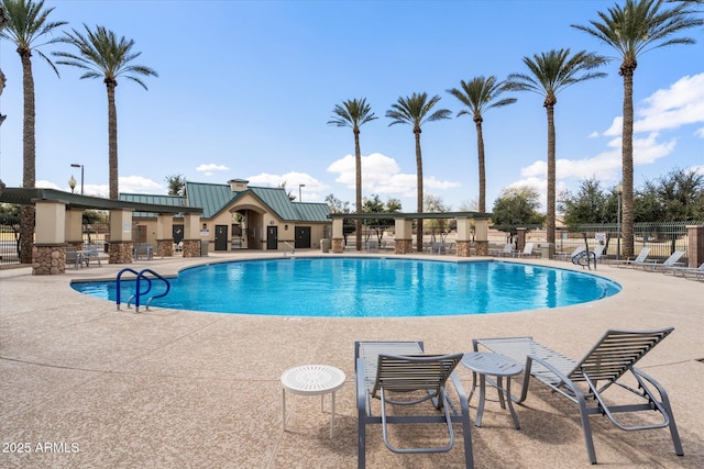 community pool with a patio and fence