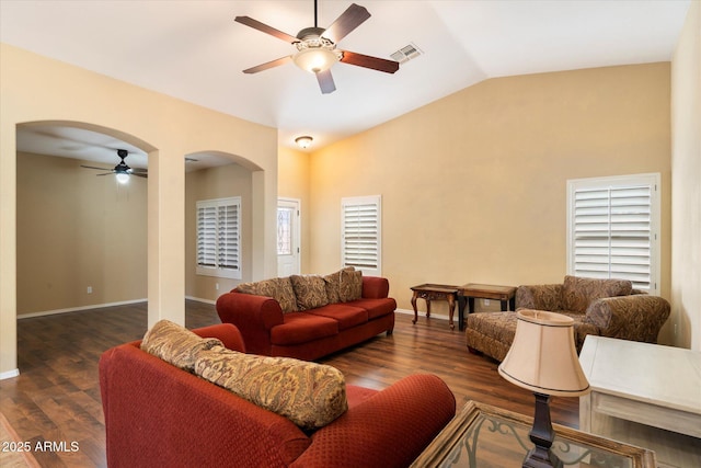 living room featuring arched walkways, visible vents, vaulted ceiling, wood finished floors, and baseboards