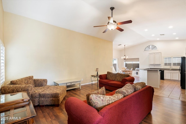 living room with recessed lighting, ceiling fan with notable chandelier, wood finished floors, visible vents, and vaulted ceiling