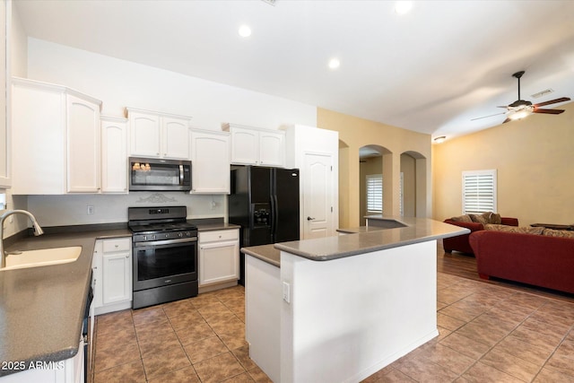 kitchen featuring white cabinets, stainless steel appliances, a sink, and open floor plan