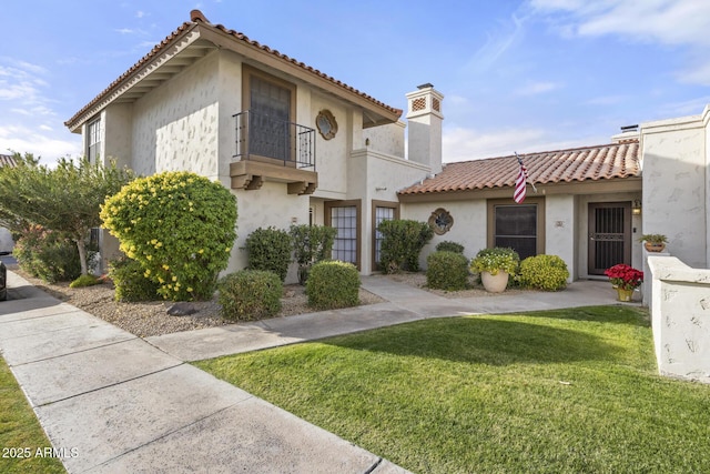 view of front of home with a front lawn and a balcony