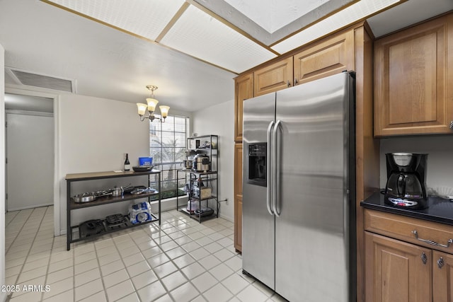 kitchen featuring decorative light fixtures, light tile patterned floors, stainless steel fridge with ice dispenser, and a chandelier