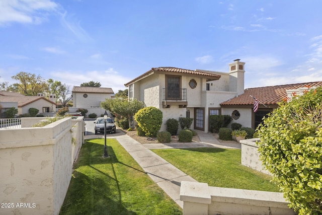 mediterranean / spanish house featuring a balcony and a front yard