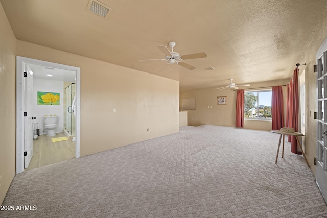 carpeted empty room with a textured ceiling and ceiling fan