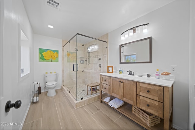 bathroom featuring toilet, vanity, and an enclosed shower