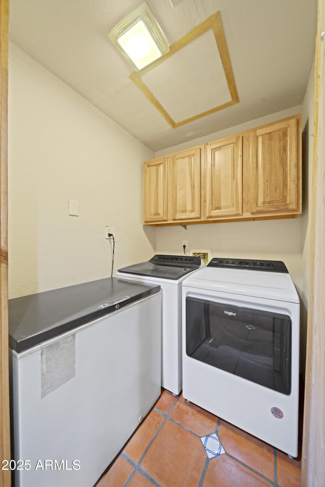 washroom with cabinets, light tile patterned flooring, and washer and clothes dryer