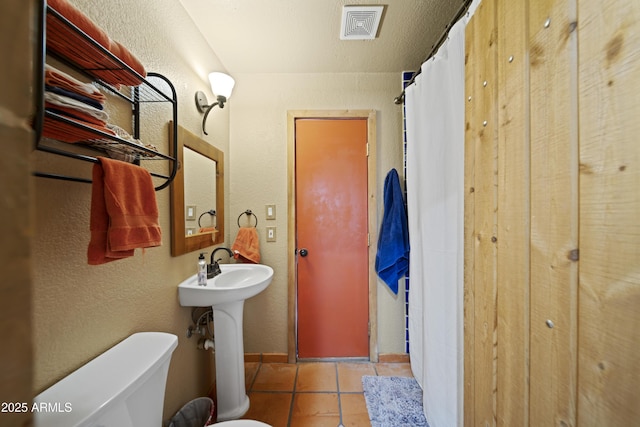 bathroom with sink, tile patterned flooring, and toilet