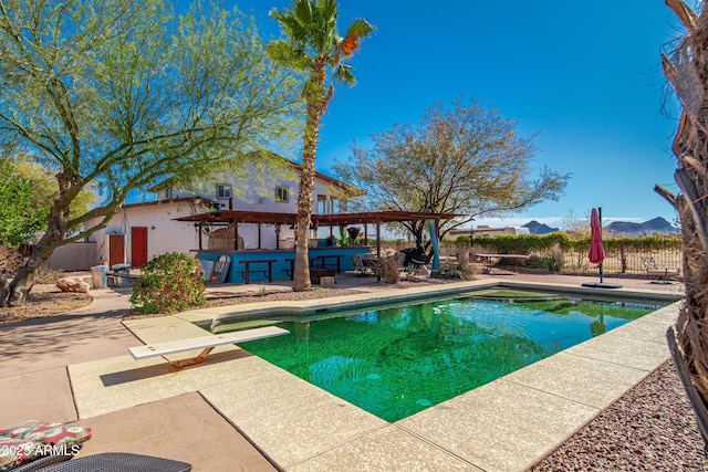 view of pool with a patio, a pergola, a bar, and a diving board