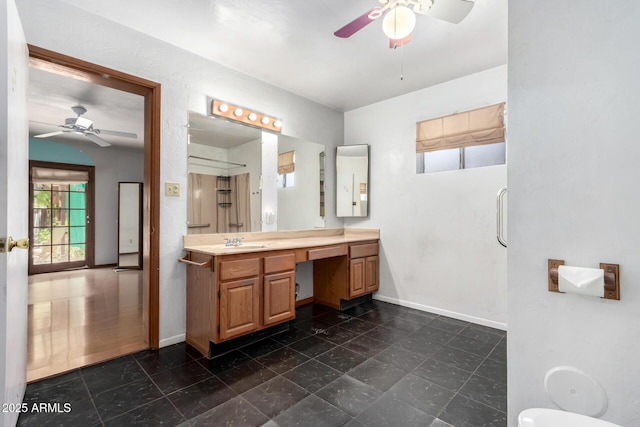 bathroom with a ceiling fan, baseboards, and vanity