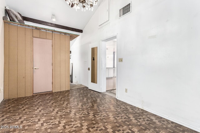 unfurnished living room featuring a chandelier and a high ceiling