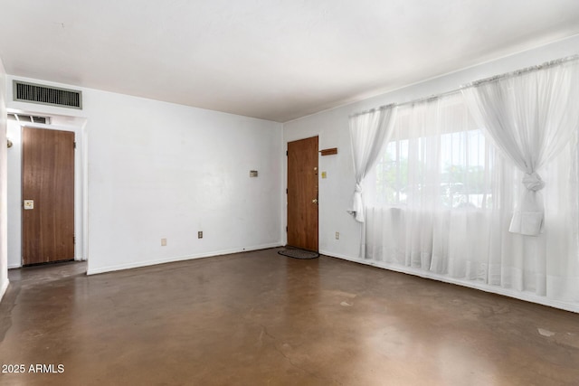 empty room with finished concrete flooring and baseboards