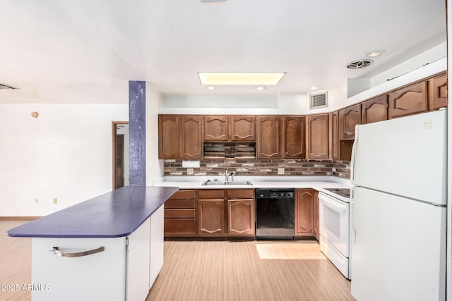 kitchen featuring white appliances, a sink, light wood-style floors, backsplash, and dark countertops