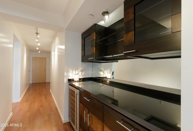 bar with light wood-type flooring, beverage cooler, and baseboards