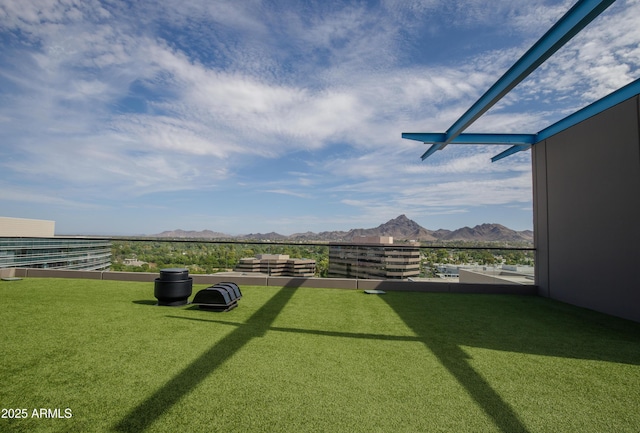 view of yard with a balcony and a mountain view