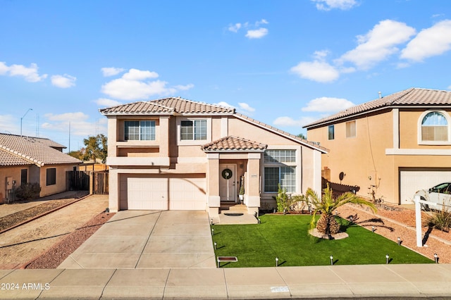 mediterranean / spanish house with a garage, stucco siding, a tile roof, and concrete driveway