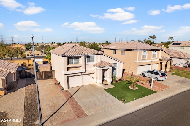 mediterranean / spanish home featuring an attached garage, concrete driveway, a tile roof, and a residential view