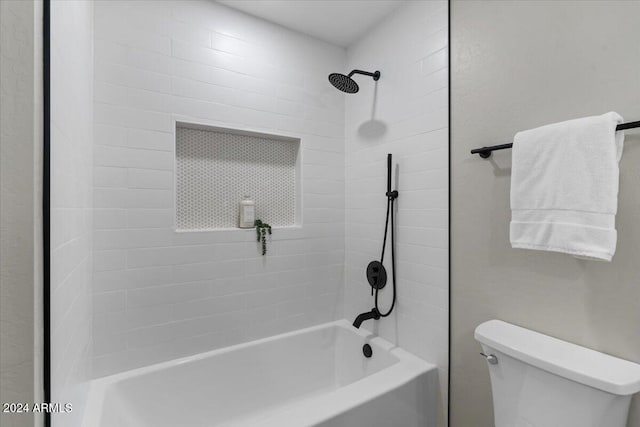 bathroom with toilet and tiled shower / bath