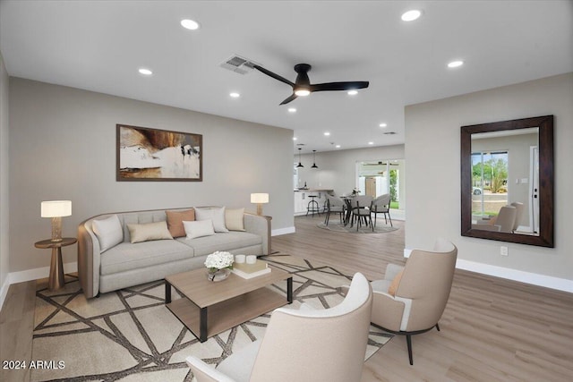 living room with light wood-type flooring and ceiling fan