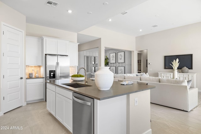 kitchen with an island with sink, white cabinets, and appliances with stainless steel finishes