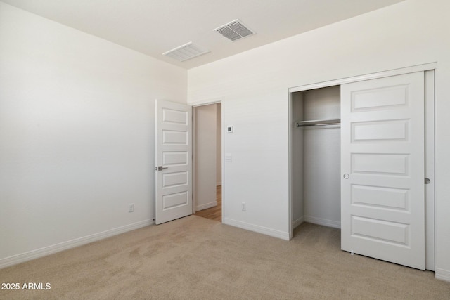 unfurnished bedroom with a closet and light carpet