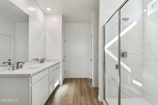 bathroom with vanity, wood-type flooring, and a shower with door