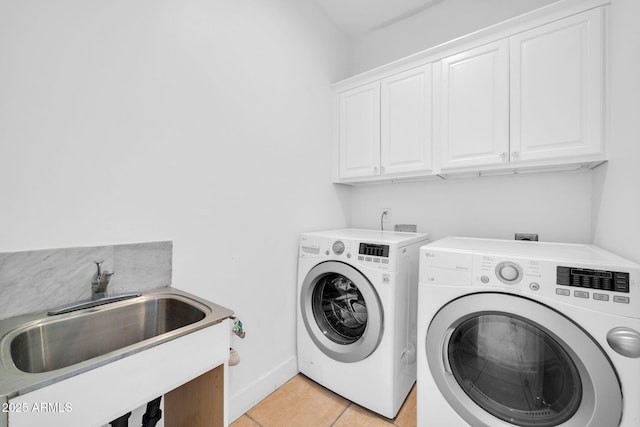 laundry room with cabinet space, light tile patterned floors, baseboards, washer and dryer, and a sink